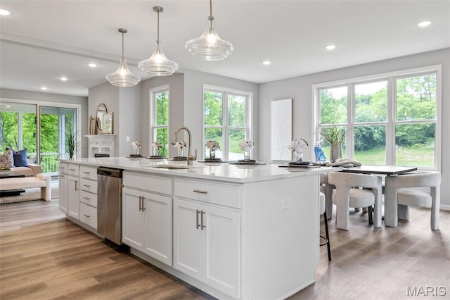 kitchen featuring a sink, stainless steel dishwasher, white cabinetry, recessed lighting, and light wood-style flooring