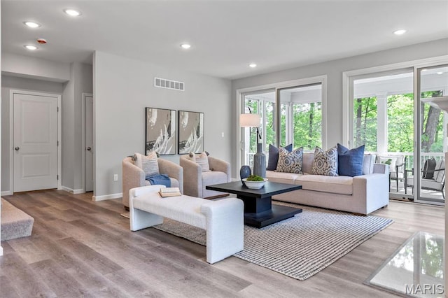 living room with light wood-style flooring, baseboards, and recessed lighting