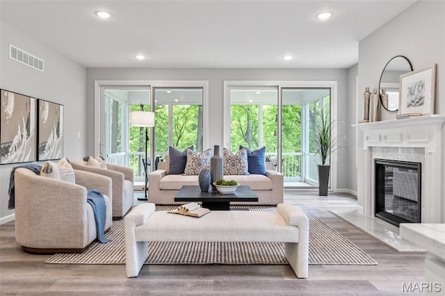living room featuring recessed lighting, wood finished floors, a fireplace, and baseboards