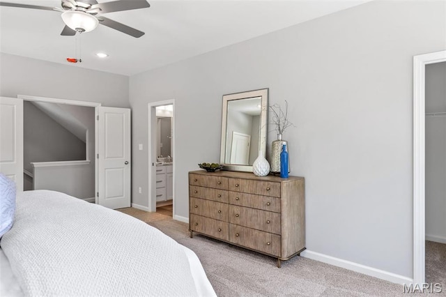 bedroom with light colored carpet, baseboards, ensuite bath, and a ceiling fan