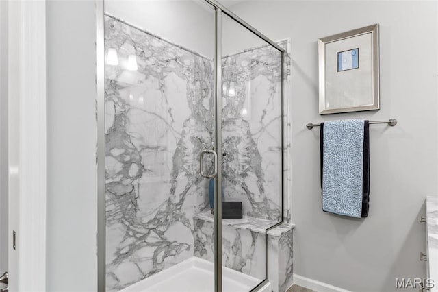 bathroom featuring a marble finish shower