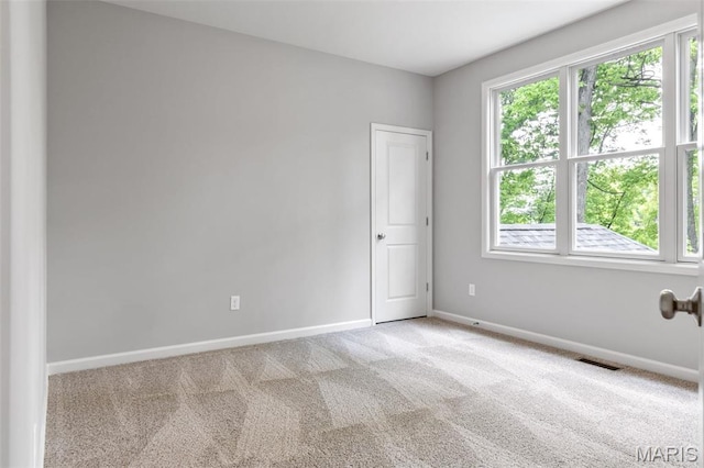 carpeted spare room featuring baseboards