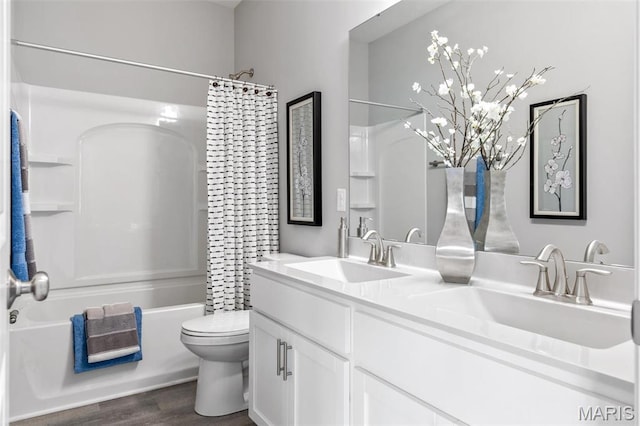full bathroom with toilet, shower / bathtub combination with curtain, double vanity, and wood finished floors