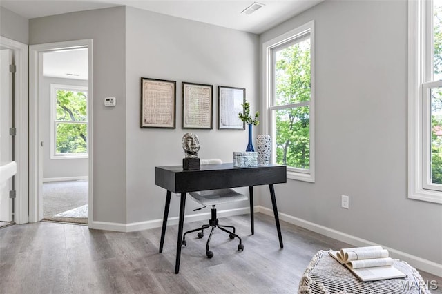 home office with wood finished floors, healthy amount of natural light, and baseboards