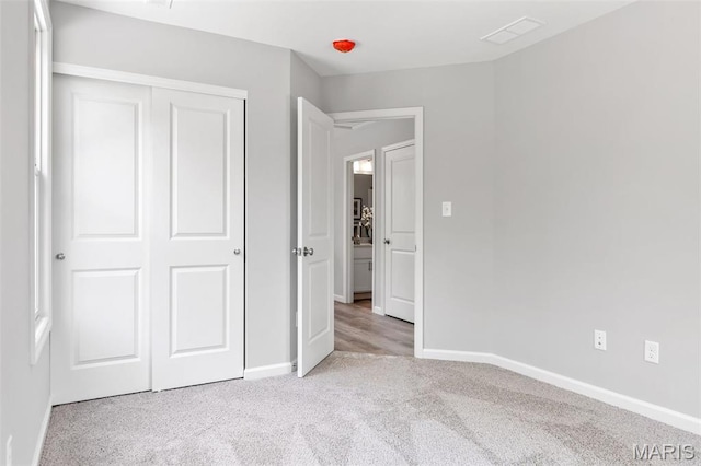 unfurnished bedroom featuring carpet flooring, baseboards, and a closet