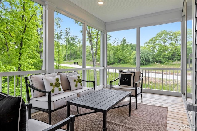 sunroom / solarium with an outdoor living space and view of scattered trees