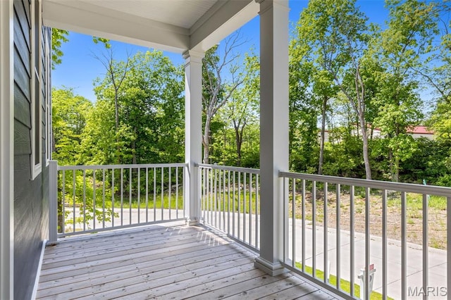 wooden terrace with view of wooded area
