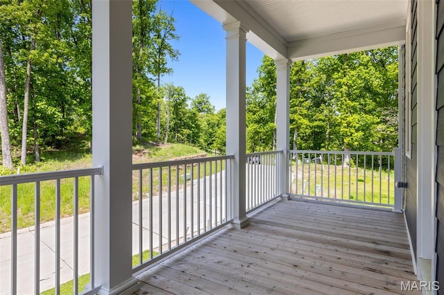 deck with a porch and view of scattered trees