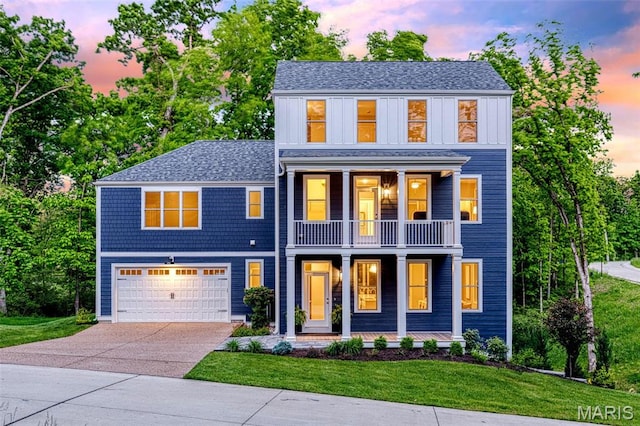 view of front of home featuring a balcony, driveway, a garage, a porch, and a yard