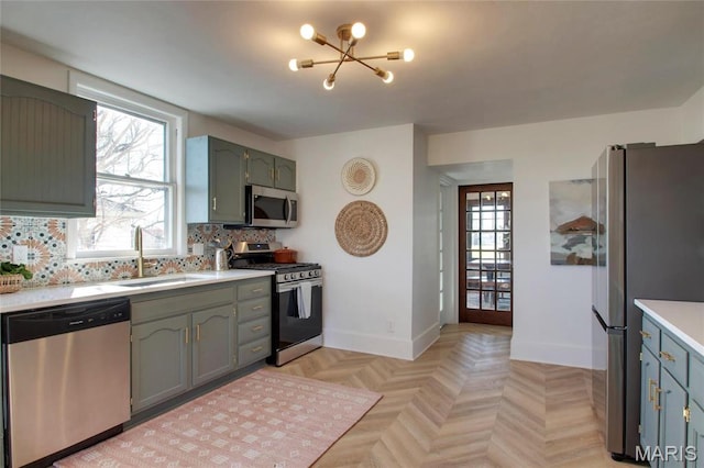410 White St, Canton, MO 63435 - kitchen featuring appliances with stainless steel finishes, a sink, light countertops, baseboards, and decorative backsplash