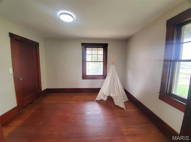 410 White St, Canton, MO 63435 - empty room with healthy amount of natural light, dark wood-style flooring, and baseboards