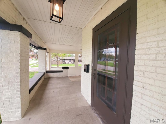 410 White St, Canton, MO 63435 - view of exterior entry featuring a porch, an attached carport, and brick siding