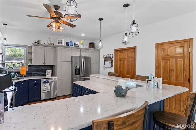 1302 Walnut St, Jerseyville, IL 62052 - kitchen with appliances with stainless steel finishes, a sink, ceiling fan, blue cabinetry, and a breakfast bar area