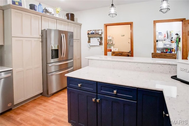 1302 Walnut St, Jerseyville, IL 62052 - kitchen featuring appliances with stainless steel finishes, blue cabinetry, light wood-style floors, and decorative light fixtures