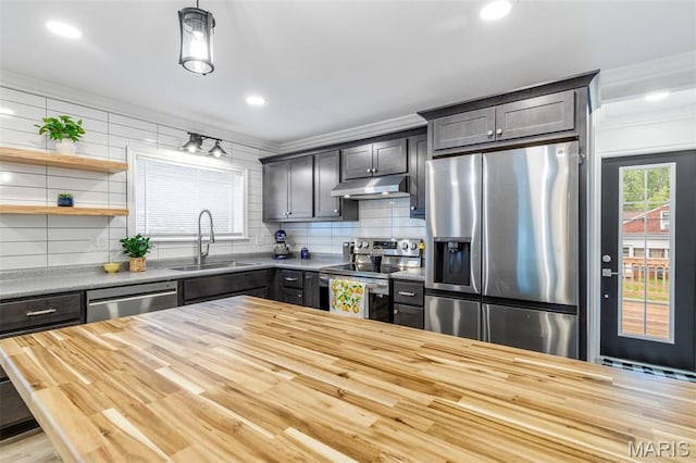 709 Warren St, Farmington, MO 63640 - kitchen with appliances with stainless steel finishes, a sink, under cabinet range hood, crown molding, and butcher block countertops