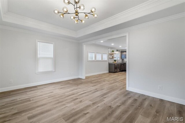 709 Warren St, Farmington, MO 63640 - unfurnished living room featuring a chandelier, ornamental molding, light wood finished floors, a sink, and baseboards
