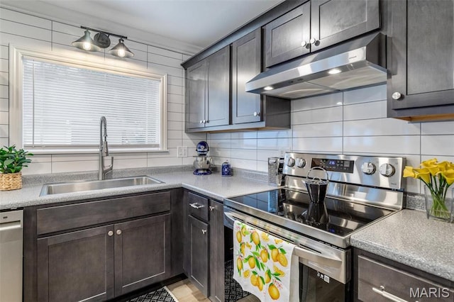 709 Warren St, Farmington, MO 63640 - kitchen featuring appliances with stainless steel finishes, under cabinet range hood, a sink, tasteful backsplash, and dark brown cabinetry