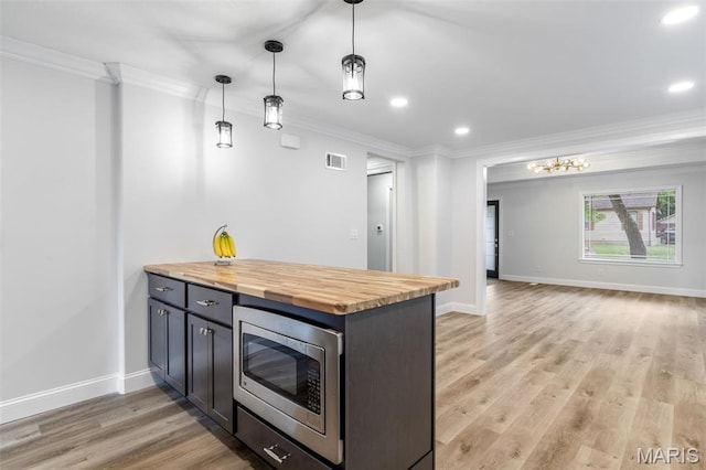709 Warren St, Farmington, MO 63640 - kitchen with stainless steel microwave, wood counters, ornamental molding, recessed lighting, and light wood finished floors