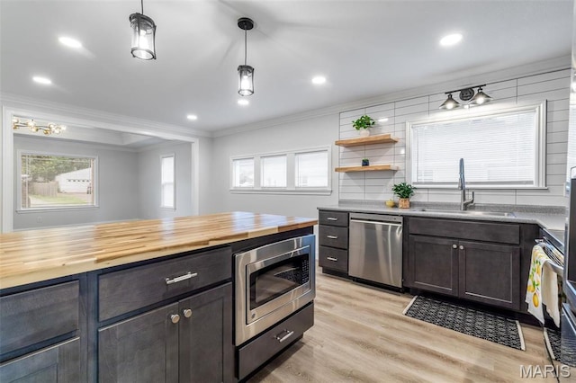 709 Warren St, Farmington, MO 63640 - kitchen featuring appliances with stainless steel finishes, a sink, crown molding, butcher block countertops, and light wood finished floors