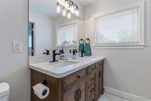 709 Warren St, Farmington, MO 63640 - bathroom with marble look tiles, double vanity, baseboards, and toilet