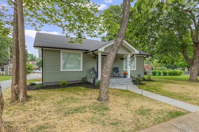 709 Warren St, Farmington, MO 63640 - bungalow-style house with covered porch, a front yard, and a shingled roof