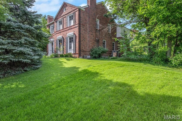 7423 Tulane Ave, Saint Louis, MO 63130 - view of side of property with a chimney, brick siding, and a yard