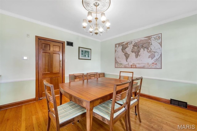 7423 Tulane Ave, Saint Louis, MO 63130 - dining room with a chandelier, light wood-style flooring, and crown molding