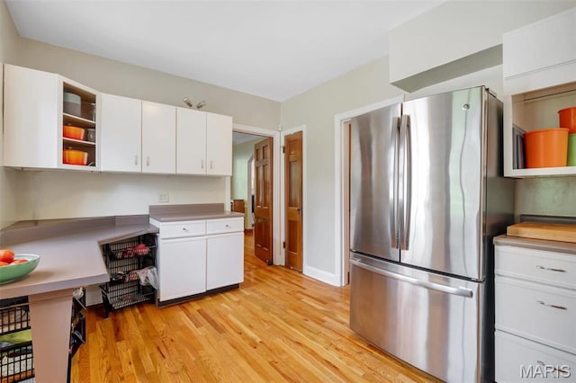 7423 Tulane Ave, Saint Louis, MO 63130 - kitchen with freestanding refrigerator, open shelves, light wood-style flooring, and white cabinetry