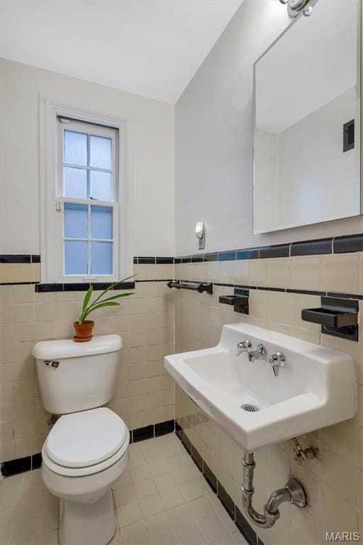 7423 Tulane Ave, Saint Louis, MO 63130 - bathroom with tile walls, tile patterned floors, and a wainscoted wall