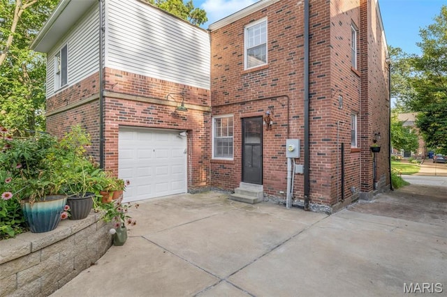 7423 Tulane Ave, Saint Louis, MO 63130 - view of front facade featuring concrete driveway, entry steps, brick siding, and a garage