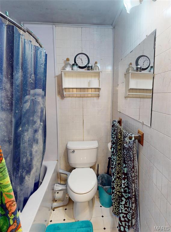 8777 State Route 162, Troy, IL 62294 - full bathroom with tile patterned floors, tile walls, toilet, and shower / bath combo with shower curtain