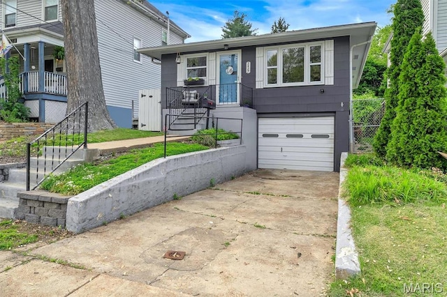 view of front of house with concrete driveway, an attached garage, and stairs