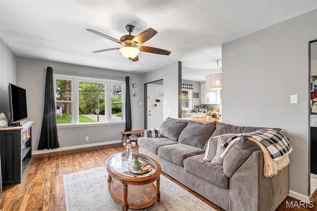 living room with ceiling fan, wood finished floors, and baseboards