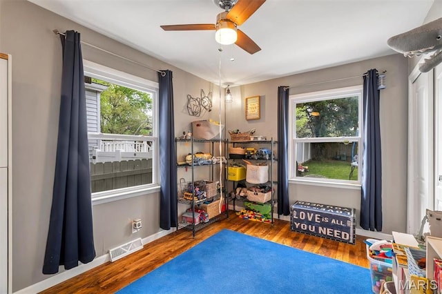 recreation room featuring a ceiling fan, wood finished floors, and baseboards