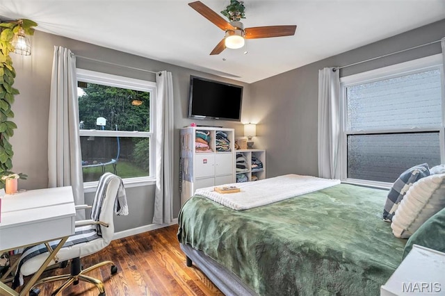 bedroom featuring wood finished floors, baseboards, and ceiling fan