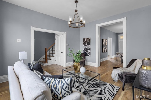 2148 Oregon Ave, Saint Louis, MO 63104 - living room featuring a chandelier, stairs, wood finished floors, and baseboards