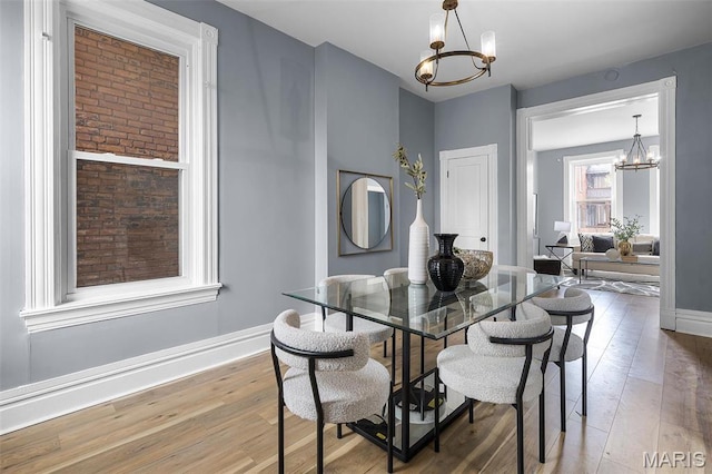 2148 Oregon Ave, Saint Louis, MO 63104 - dining room featuring a chandelier, wood finished floors, and baseboards
