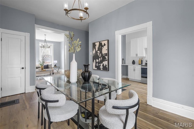 2148 Oregon Ave, Saint Louis, MO 63104 - dining space featuring a chandelier, wood finished floors, and baseboards
