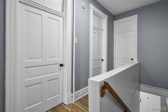 2148 Oregon Ave, Saint Louis, MO 63104 - hall with wood finished floors, a textured wall, and an upstairs landing