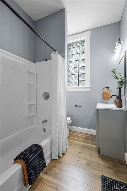 2148 Oregon Ave, Saint Louis, MO 63104 - full bathroom with toilet, wood finished floors, vanity, shower / tub combo with curtain, and baseboards
