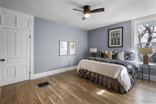 2148 Oregon Ave, Saint Louis, MO 63104 - bedroom with a textured ceiling, baseboards, wood-type flooring, and a ceiling fan