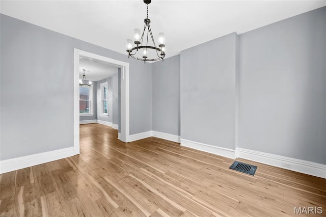 2148 Oregon Ave, Saint Louis, MO 63104 - unfurnished dining area featuring a chandelier, baseboards, and wood-type flooring