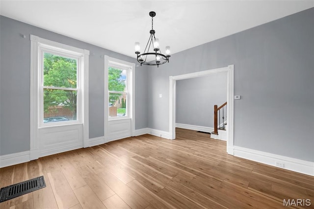 2148 Oregon Ave, Saint Louis, MO 63104 - unfurnished dining area featuring a chandelier, hardwood / wood-style flooring, and baseboards
