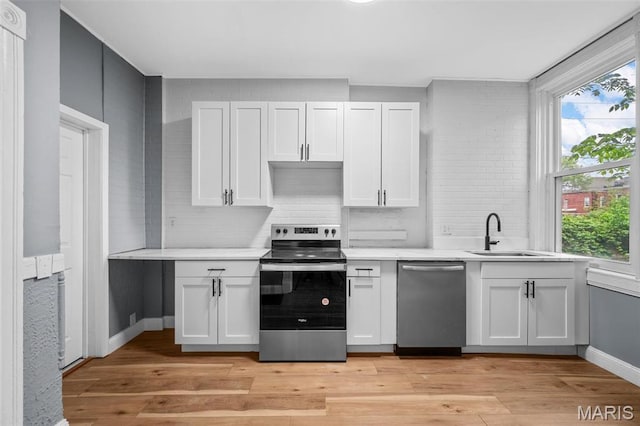 2148 Oregon Ave, Saint Louis, MO 63104 - kitchen with appliances with stainless steel finishes, a sink, light countertops, and decorative backsplash