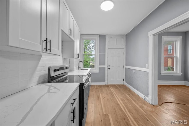 2148 Oregon Ave, Saint Louis, MO 63104 - kitchen featuring electric range oven, a sink, light stone counters, and light wood-style floors