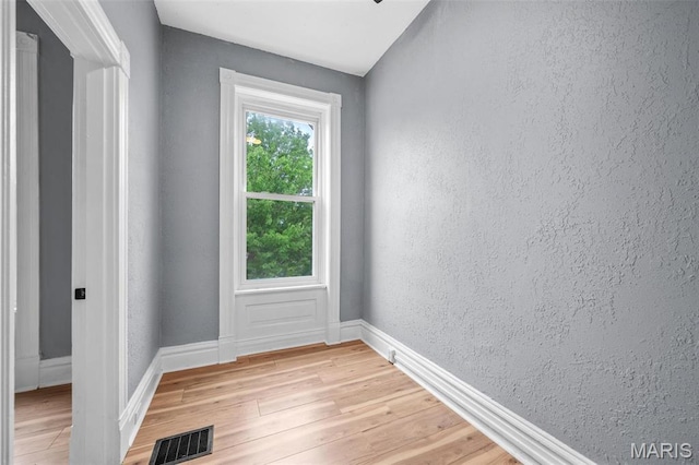 2148 Oregon Ave, Saint Louis, MO 63104 - doorway with healthy amount of natural light, a textured wall, light wood-style flooring, and baseboards