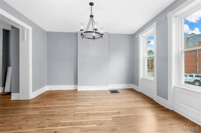 2148 Oregon Ave, Saint Louis, MO 63104 - unfurnished dining area with a chandelier, light wood-style flooring, and baseboards