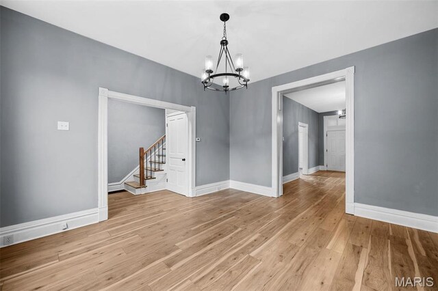 2148 Oregon Ave, Saint Louis, MO 63104 - unfurnished room with a chandelier, stairs, light wood-type flooring, and baseboards