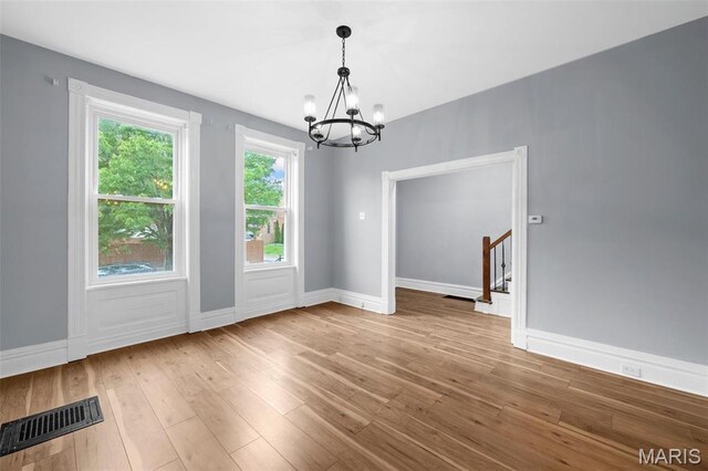 2148 Oregon Ave, Saint Louis, MO 63104 - unfurnished dining area with a chandelier, hardwood / wood-style floors, and baseboards