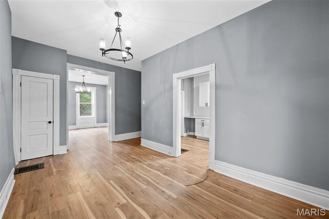 2148 Oregon Ave, Saint Louis, MO 63104 - unfurnished dining area featuring a chandelier, baseboards, and light wood-style floors